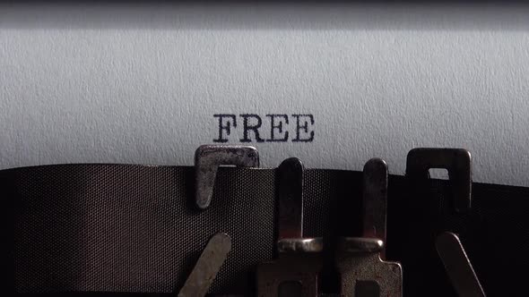 Typing word Free on retro typewriter. Close up. alt