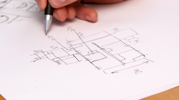Person's Hand Drawing Plan On Blue Print. Close-up alt