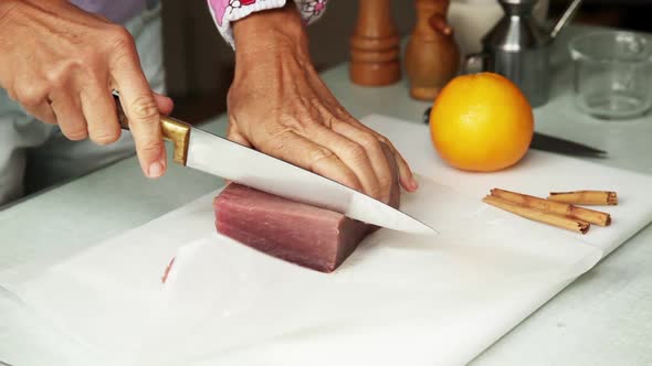 Woman slicing fresh tuna alt