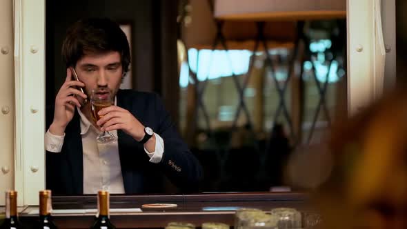 Young Successful Businessman Speaking on Phone in Cafe alt