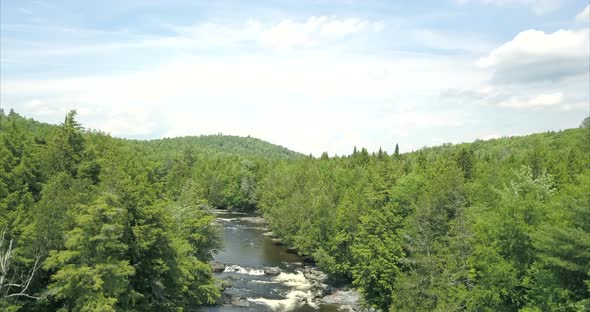 Rising high above a river and the forest at Tobey Falls near Willimantic, Maine. alt