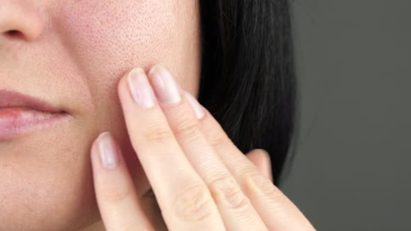 The Girl Examines the Problem Skin with Enlarged Pores Touching Her Face with Her Fingers alt