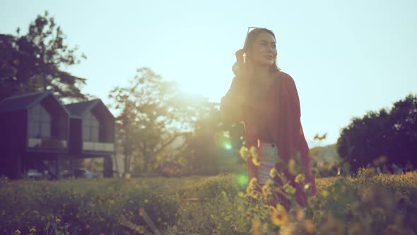 asian female woman walking in yellow blossom flower sunset moment
