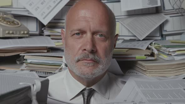 Stressed businessman overloaded with paperwork