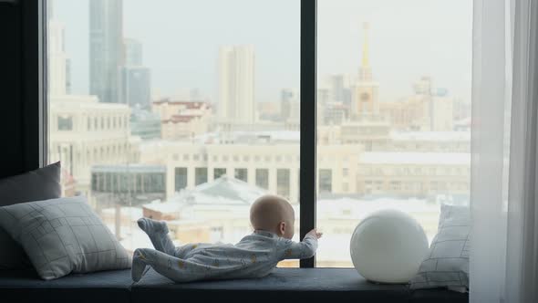 the baby lies on the windowsill with a lamp, the lamp lights up