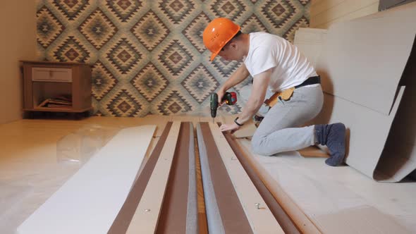 A Worker Builds a Bed in the Bedroom