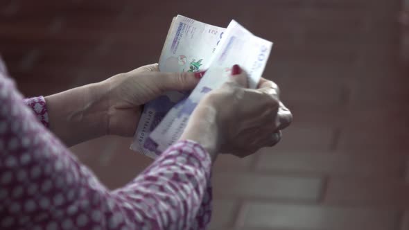 woman's hands count Colombian money