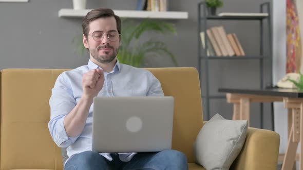 Young Man with Laptop Having Wrist Pain on Sofa alt