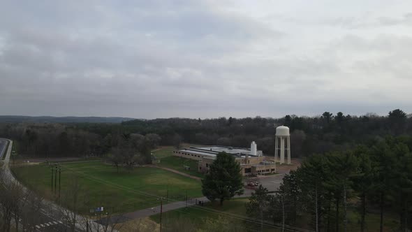 Valley in Wisconsin with water tower and lush forest surrounding on a gray, cloudy day.