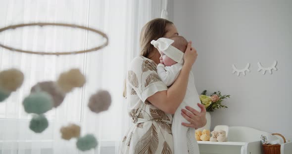 Young Beautiful Mother Holds Her Adorable Newborn Baby on Hands alt