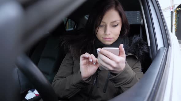Woman Using Smartphone and Celebrating Success While Sitting in Car alt