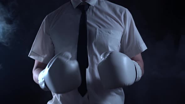 A Businessman in Boxing Gloves Adjusts His Tie