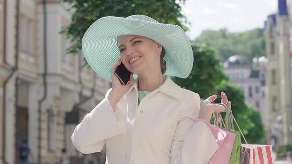 Portrait of Happy Excited Woman Talking on the Phone on Sunny City Street. Beautiful Brunette alt