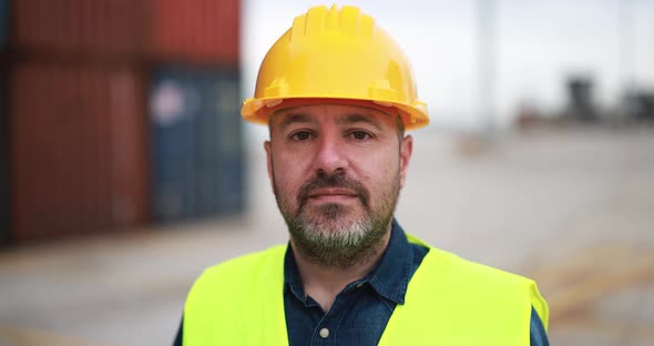 Man looking on camera working at freight terminal port on background alt