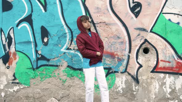 New generation kid in front of his graffiti painted wall. alt