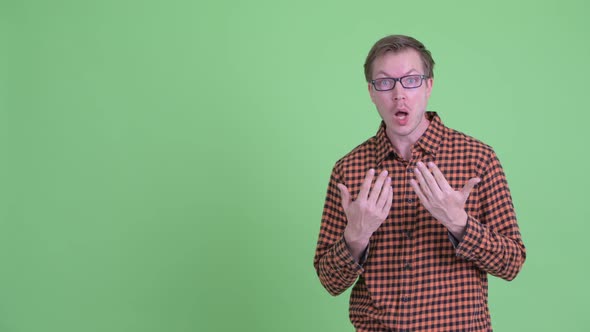 Happy Young Hipster Man Showing Something and Looking Surprised alt