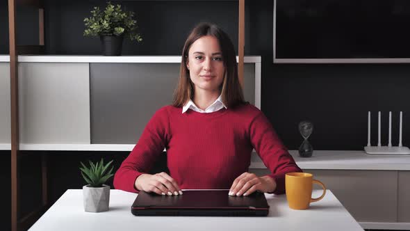 Head Shot of Young Woman Wearing Sitting at the Desk Pose in Office Room Looking at Camera Laughing alt