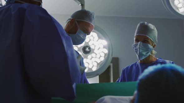 Low angle view of surgeons operating pregnant woman in operation theater  alt