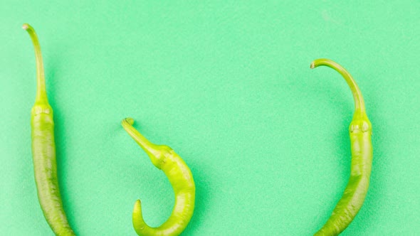 Hot Green Pepper Lies on a Pastel Green Background alt