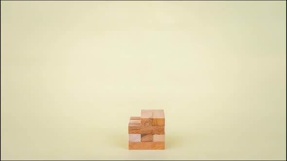 Stop motion animation Game with wooden blocks on yellow background.