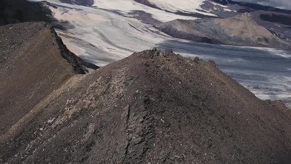 Aerial Flight of a Man Climbing Up Difficult Mountain Rock Slope