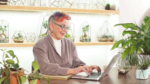 Portrait of Openminded Business Lady with Glasses Smile While Sitting on Table with Notebooks and alt