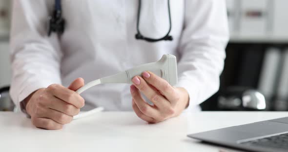 The Doctor Holds a Probe for Ultrasound Closeup alt