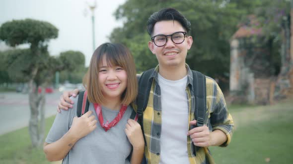 Asian couple feeling happy smiling to camera holiday trip at Ayutthaya, Thailand, backpacker enjoy alt