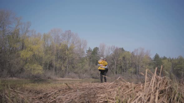 Blond Woman Running To the Bearded Handsome Man and Jump at His Hugs. Amazing View of River and alt