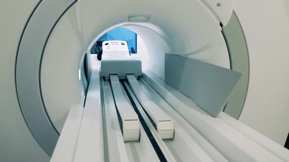 Patient on a Table Is Moving Into a CT Scanner alt