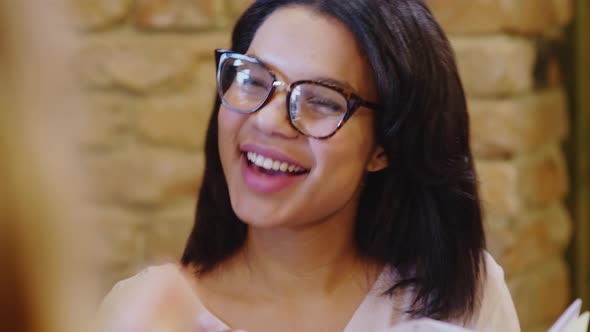 Pretty Latin Businesswoman in Eyeglasses Speaking with Colleagues 