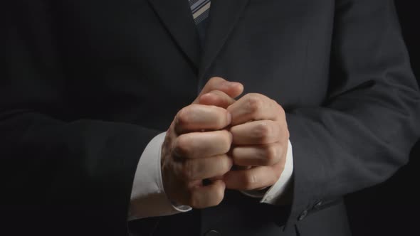 Businessman rubs hands in a nervous