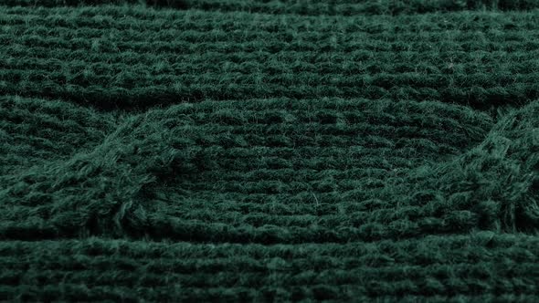 Pigtails on Green Knitwear Fabric Texture. Machine Knitting Texture Macro Snapshot.