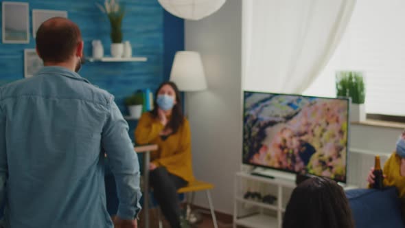 Man Coming at Party with Friends Wearing Face Mask alt