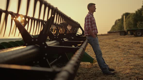 Farmer Relax Golden Field at Combine Harvester Alone alt
