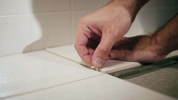 Builder Laying Tiles Using Cement Closeup Man Installing Ceramic Slabs on Floor and Walls alt