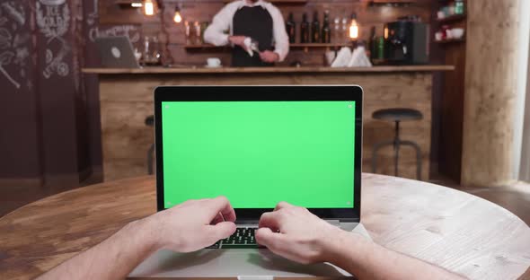 POV Footage of Male Hands Typing on Computer with Green Screen alt
