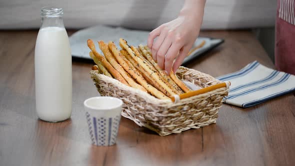 Grissini Breadsticks, Sesame-Covered Bread Sticks. Fresh bread sticks in a basket. alt