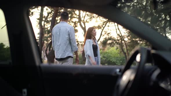 Shooting From Car of Caucasian Couple Gesturing Hitchhiking Standing in Suburb Forest alt