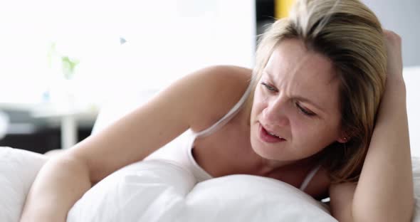Awakened Woman Screams and Looks at Alarm Clock alt