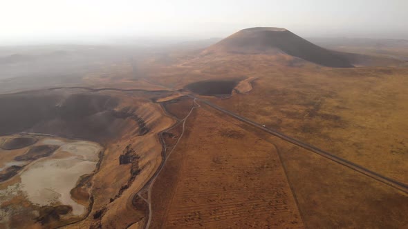 Mars Rover Moving on a Road Near Volcanic Cone and Crater on Red Planet