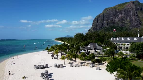 Ascending aerial shot showing mauritian coastline with sandy beach and palm trees alt