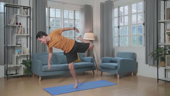 Asian Man Can't Do Yoga In Law Lord Of The Dance Pose On Mat At Home alt