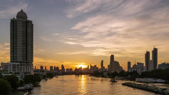 Dramatic sun rises over Chao Phraya River, Bangkok downtown city center - time lapse