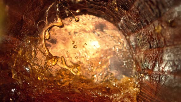 Super Slow Motion Shot of Splashing Whiskey in Old Oak Barrel at 1000Fps alt