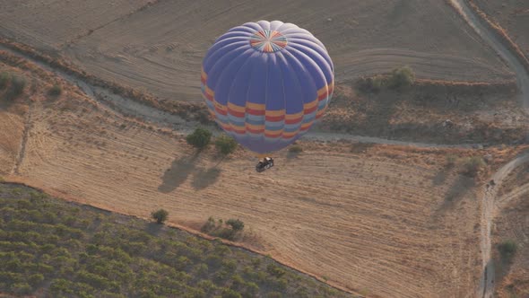 Colourful Hot Air Balloon with Large Brown Basket Floats alt