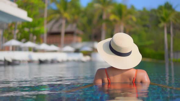 Young asian woman enjoy around outdoor swimming pool for leisure alt