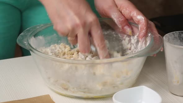 A Woman Is Stirring The Dough For Making Biscuit Cookies. alt