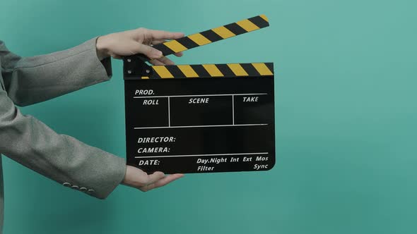 Movie slate or clapperboard hitting. Business woman holding empty film slate and clapping it.