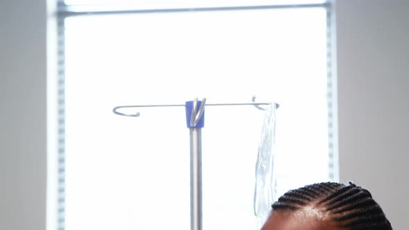 Portrait of sick girl holding iv drip stand alt